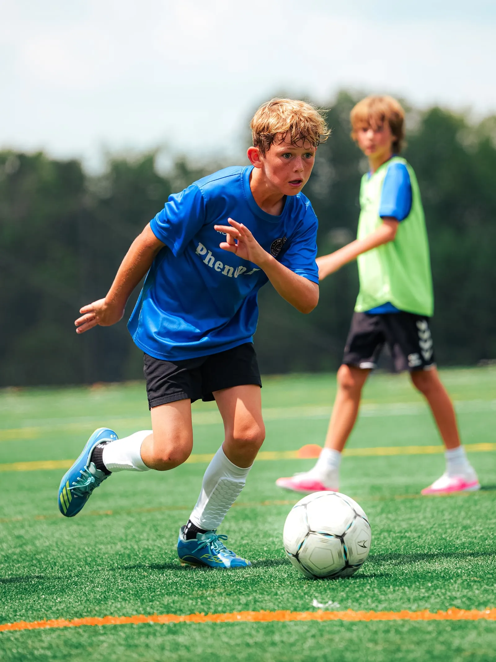 A Phenom Elite player driving forward with the ball during a training session